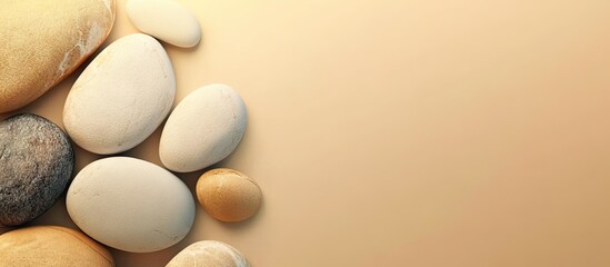 Poster - Numerous pebble stones on a beige background. with copy space image. Place for adding text or design
