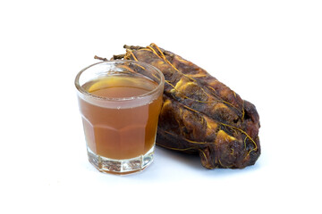 Groups of ripe brown dried Sour Tamarind, tamarind , tamarin and juice in a glass, edible fruit, sour taste, important sour seasoning in Thai food, isolated on white background closed up. 