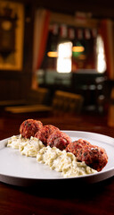 close up of portion of meatloaf with mayonnaise madeira at happy hour blurred pub background