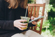 © ADDICTIVE STOCK - Teenage girl enjoying ice matcha while using smartphone