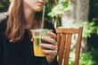 © ADDICTIVE STOCK - Teenager girl enjoys a chilled matcha ice tea drink outdoors