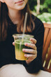 © ADDICTIVE STOCK - Teenage girl holding a layered matcha ice tea
