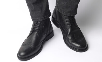 Poster - Male legs in black leather brogue boots on a white background