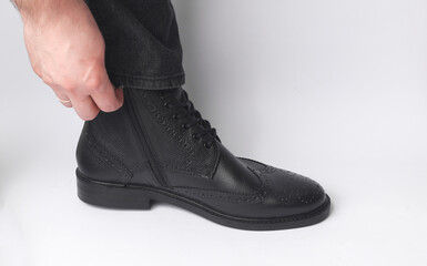 Sticker - Male leg in black leather brogue boot on a white background