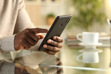 Black man hands using cell phone on a desk