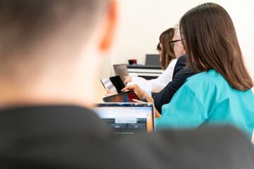 Wall Mural - A group of people in a meeting room,  medical professionals, working on laptops and discussing something. 