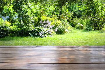 Empty wooden table with garden bokeh background with a country outdoor theme