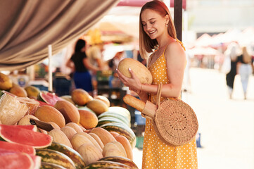 Wall Mural - Yellow dress, and with watermelon. Young woman is on the vegetable market or bazaar