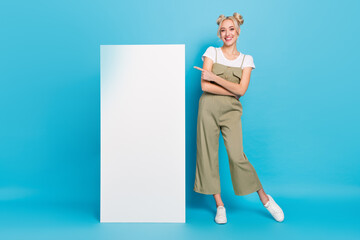 Wall Mural - Full length photo of sweet blond lady indicate placard wear t-shirt overall sneakers isolated on blue background