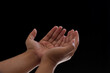 © Muzadi - Close-up of two hands showing supplication or prayer. Photo isolated on black background
