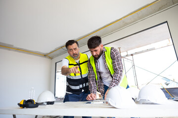 Wall Mural - blueprint. Builders and architect looking at plans. employees in construction industry