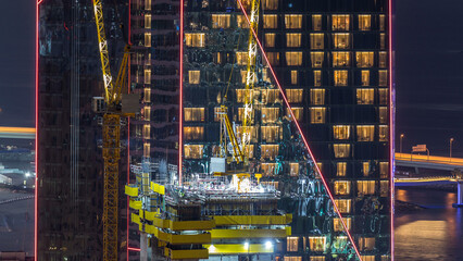 Wall Mural - Construction site with crane at JBR night timelapse. Building of skyscrapers.