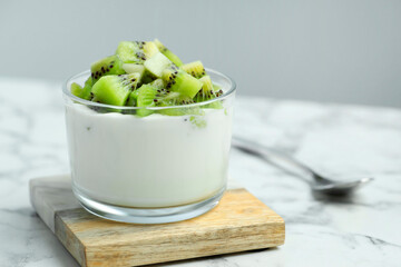 Poster - Tasty yogurt with fresh kiwi in glass on white marble table, closeup