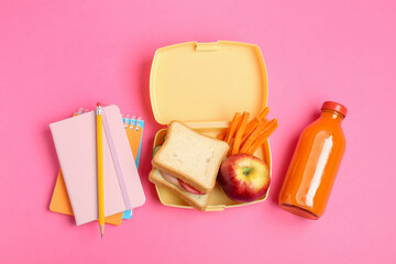 Wall Mural - Lunch box with snacks, bottle of juice and stationery on pink background, flat lay