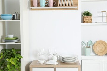 Wall Mural - Shelving unit with different kitchenware near white wall indoors