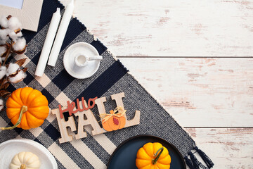 Wall Mural - Flat lay composition with warm plaid, autumn decor, pumpkins, candles on rustic wooden table. Top view.