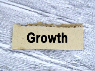 Growth wording or text on ripped paper edge cardboard with grey background.Copy space and business concept.