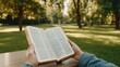 © lililia - A man in jeans reads the Bible while seated at a wooden table, surrounded by lush greenery and sunlight streaming through the trees, creating a peaceful atmosphere for contemplation.