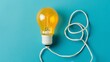 © poom - Yellow light bulb on a blue background with a tangled white cord beside it