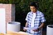 © Wavebreak Media - Reviewing blueprints, asian man in checkered shirt working on outdoor construction project