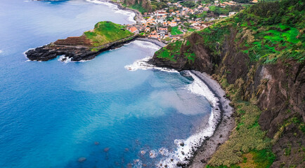 Aerial view of rough ocean with waves, volcanic beach in Porto da Cruz, Madeira, Portugal