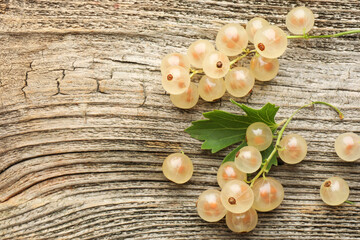 Canvas Print - Fresh white currant berries and green leaf on wooden table, top view. Space for text