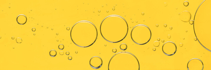 Poster - Sample of cosmetic oil on yellow background, macro view