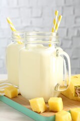 Sticker - Tasty pineapple smoothie in mason jars and fresh fruit on table