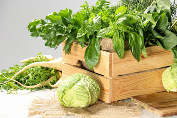 Wall Mural - Different fresh herbs and cabbages on white table, closeup