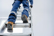 © LidiaLens - Construction worker climbing a ladder in safety gear, showcasing focus on protective clothing and secure work environment