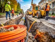 © Man888 - A close-up of a fiber optic cable being carefully placed into a trench alongside a road during construction,