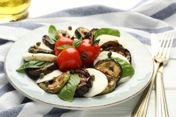 Tasty salad with grilled vegetables and mozzarella cheese served on white wooden table, closeup