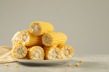 Wall Mural - Halves of fresh ripe corncobs on grey table. Space for text