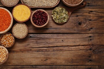 Wall Mural - Different types of cereals, seeds and legumes on wooden table, flat lay. Space for text