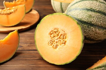 Wall Mural - Cut Cantaloupe melon on wooden table, closeup