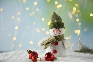 Wall Mural - Cute decorative snowman and Christmas balls on artificial snow