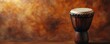 © Georgii - Beautifully crafted African drum with intricate design against a warm, textured background, ideal for music and cultural themes