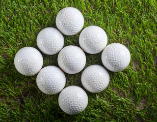 A group of golf balls are on a green grass field