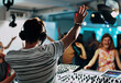 © Nedrofly - DJ performing at a lively party with dancing crowd