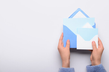 Wall Mural - Female hands with envelopes and blank cards on white background, closeup