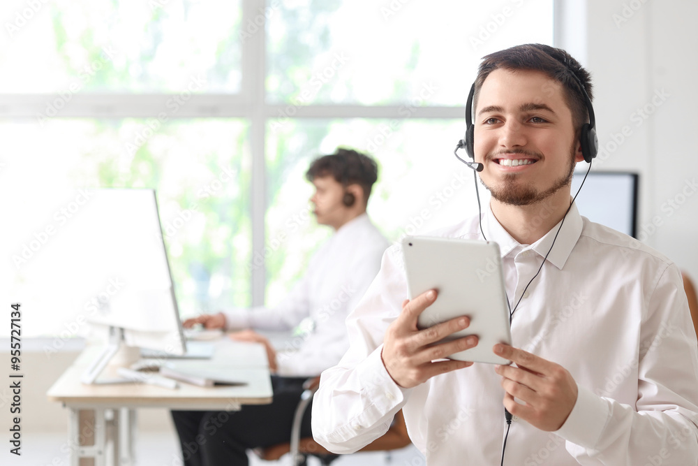Male technical support agent with tablet computer in office