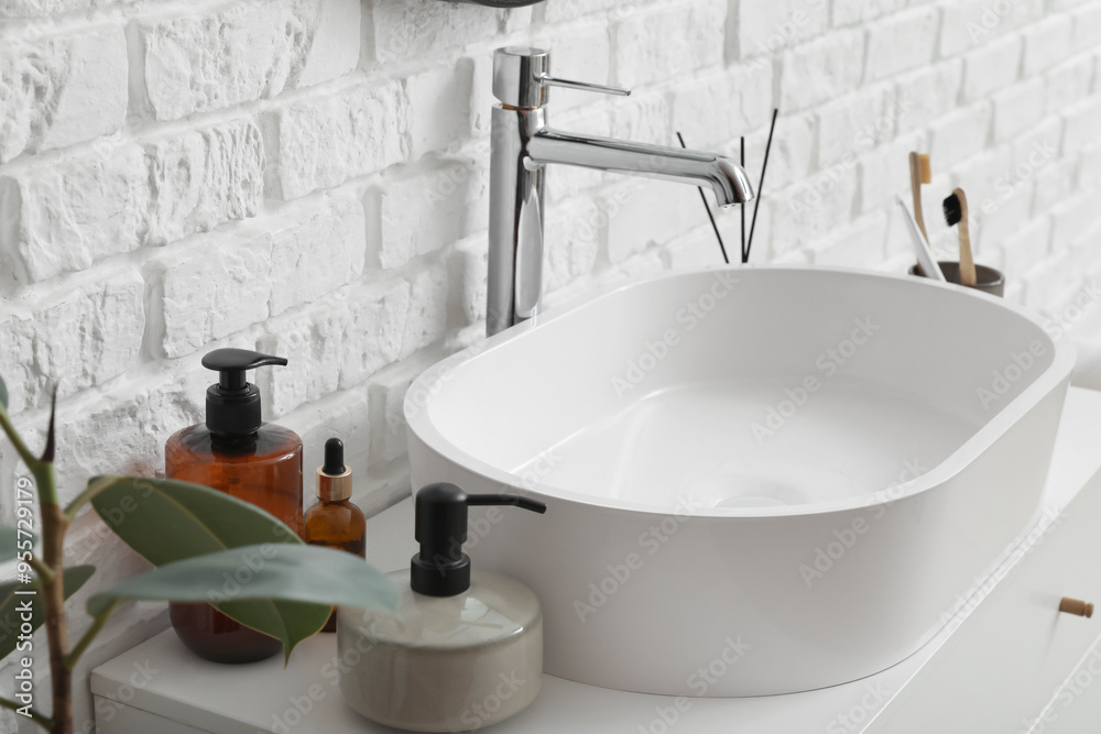 Sink bowl and bath accessories on table in bathroom, closeup