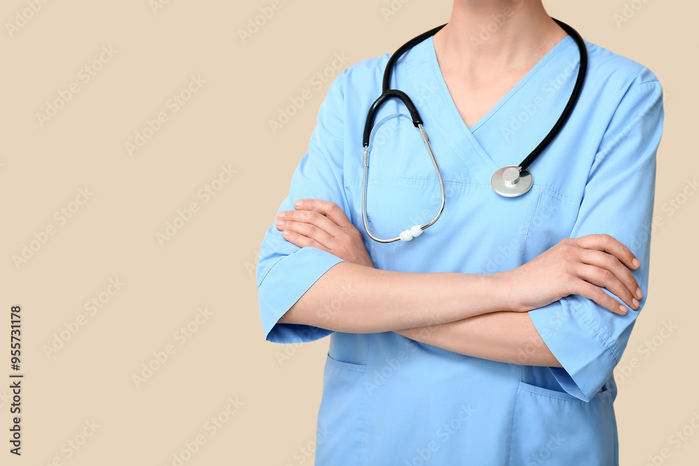 Female doctor with stethoscope on beige background