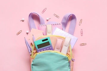 Wall Mural - Colorful school backpack with calculator, notebooks and markers on pink background