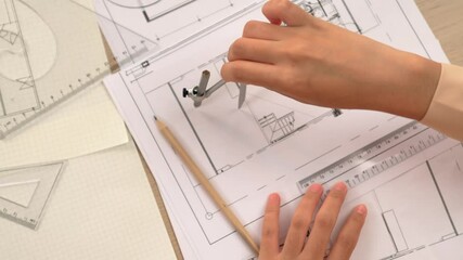 Wall Mural - Video of clever architect or smart engineer using measurement tool and divider hand writing detail on blueprint for construction accuracy at architectural office. Focus on hand. Closeup. Delineation.