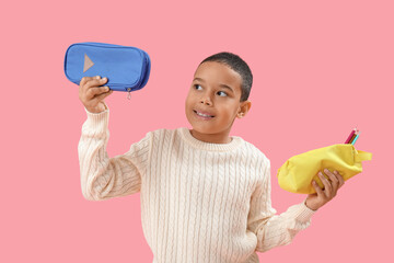 Poster - Little African-American boy with pencil cases on pink background