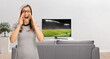 © Ljupco Smokovski - Blond woman with glasses watching football and shouting in front of tv