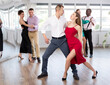 © JackF - Active young lady training waltz in pair with man in dance-hall during dancing classes