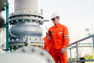 a man worker engineer conducts a site inspection at an industrial facility of gas and oil petroleum industry with utilizing a tablet for data management. technology and safety in maintaining operation