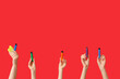 © Pixel-Shot - Many hands holding electronic cigarettes on red background